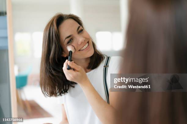 pretty woman applying make up, using mascara - gesichtspuder stock-fotos und bilder
