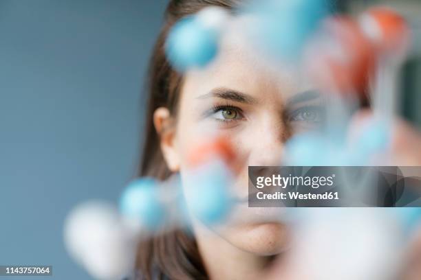 female scientist studying molecule model, looking for solutions - neugierde stock-fotos und bilder