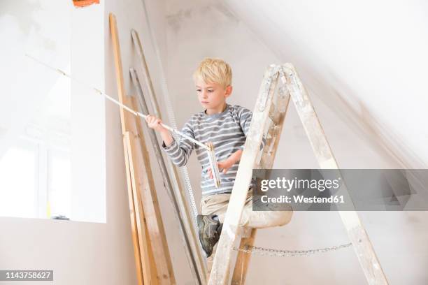 boy with pocket rule on ladder in attic to be renovated - step ladder stock pictures, royalty-free photos & images
