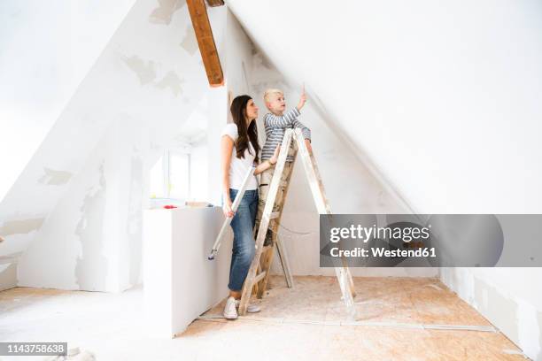 mother and son working on loft conversion - dachgeschoß stock-fotos und bilder
