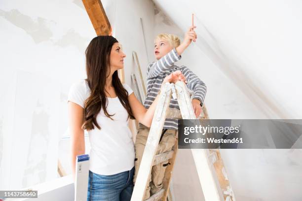 mother and son working on loft conversion - attic conversion stockfoto's en -beelden