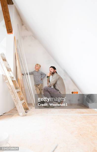 father and son planning loft conversion - attic conversion stockfoto's en -beelden