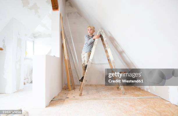 boy standing on ladder in attic to be renovated - attic conversion stock pictures, royalty-free photos & images