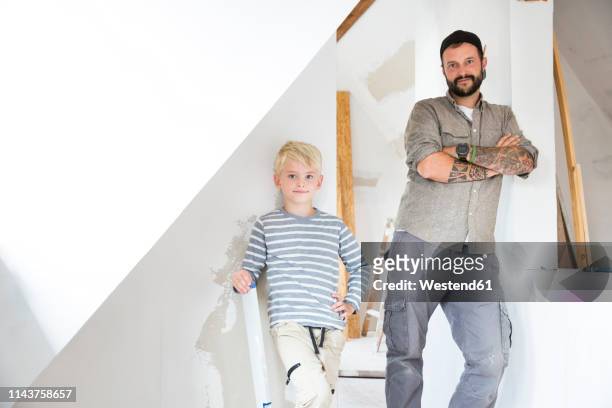 portrait of confident father and son working on loft conversion - attic conversion stockfoto's en -beelden