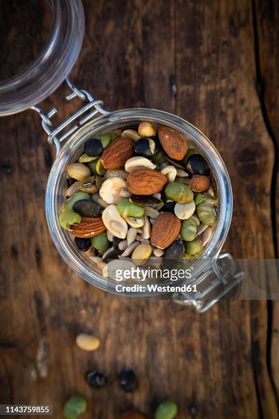 preserving jar of roasted soy beans, seeds and nuts on wood - hülsenfrucht stock-fotos und bilder