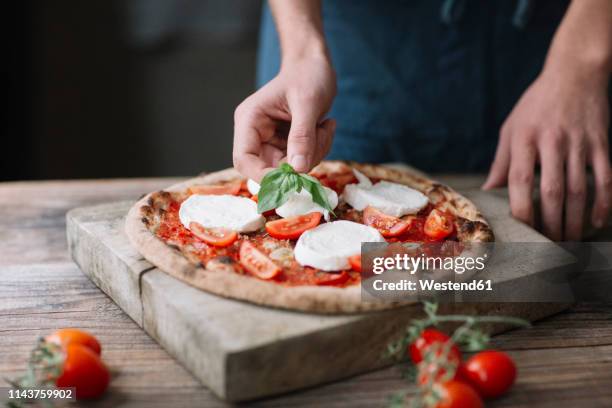 young man preparing pizza - garnish stock pictures, royalty-free photos & images