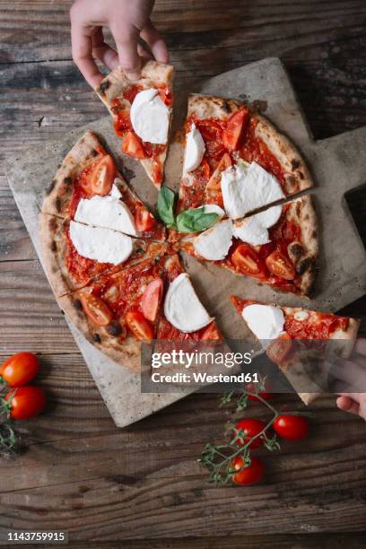 eating a pizza with mozzarella, hand taking pizza slice - pizza slice overhead stock pictures, royalty-free photos & images