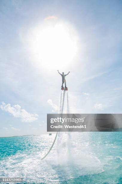 maldives, man on flyboard above the sea - fountain stock pictures, royalty-free photos & images