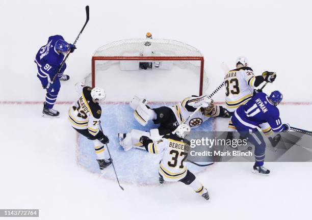 Tuukka Rask, Zdeno Chara, Patrice Bergeron, and Charlie McAvoy of the Boston Bruins guard the net against the Zach Hyman and John Tavares of the...