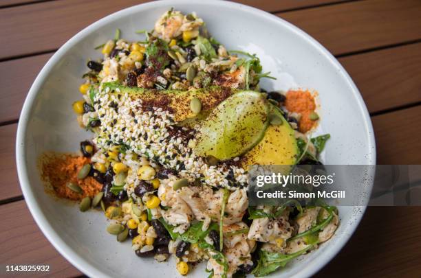 chimichurri chicken salad (brown rice, black beans, kale, charred corn, avocado, pepitas, tomato & romesco) - rice australia stock pictures, royalty-free photos & images