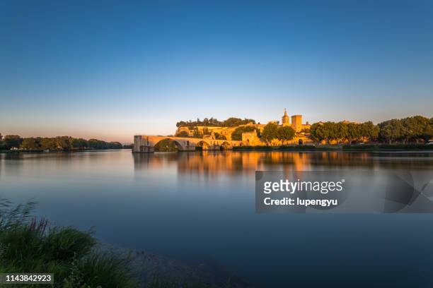 pont saint-benezet on rhone river and avignon cathedral at sunset,avignon - rhone river stock pictures, royalty-free photos & images