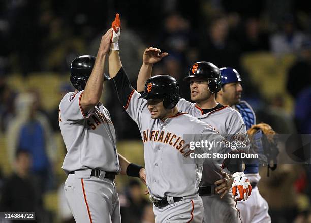 Cody Ross of the San Francisco Giants is greeted by Nate Schierholtz and Freddy Sanchez after hitting a three run home run in the ninth inning...