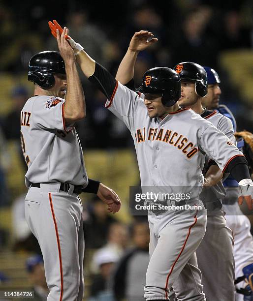 Cody Ross of the San Francisco Giants is greeted by Nate Schierholtz and Freddy Sanchez after hitting a three run home run in the ninth inning...