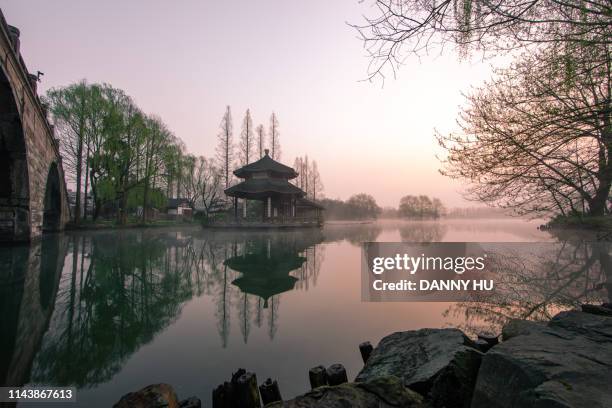 west lake in hangzhou at dawn - classical chinese garden fotografías e imágenes de stock