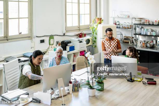 creative executives working on computers at desk - disability collection stock pictures, royalty-free photos & images