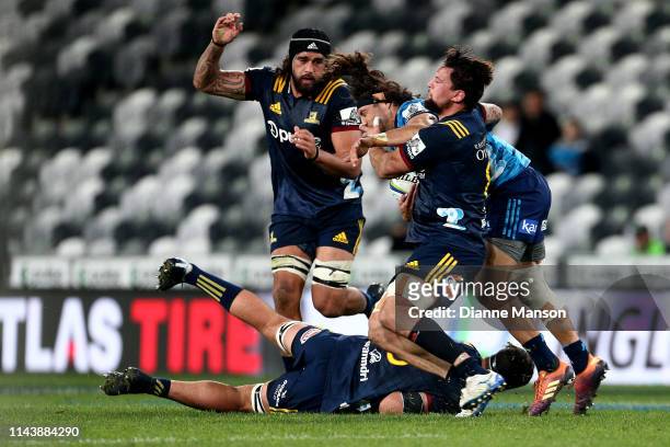 Jonathan Ruru of the Blues is tackled by Elliot Dixon of the Highlanders during the round 10 Super Rugby match between the Highlanders and the Blues...