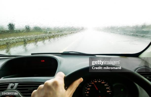 view of a car dashboard and a window during rain - driving rain stock pictures, royalty-free photos & images