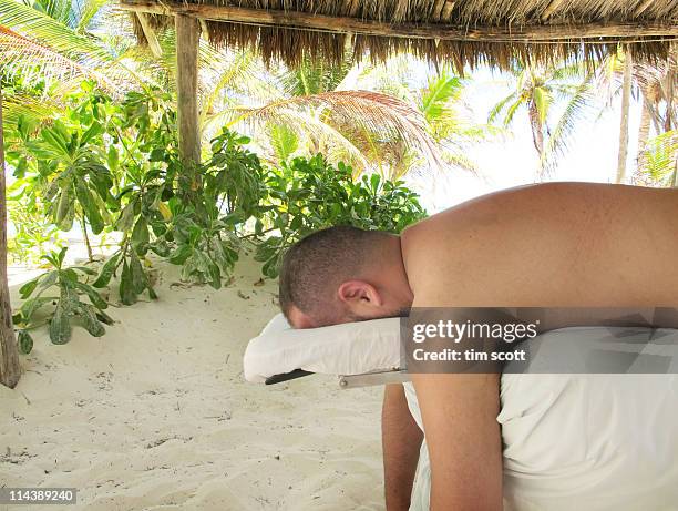 man on massage table at beach - banc de massage photos et images de collection