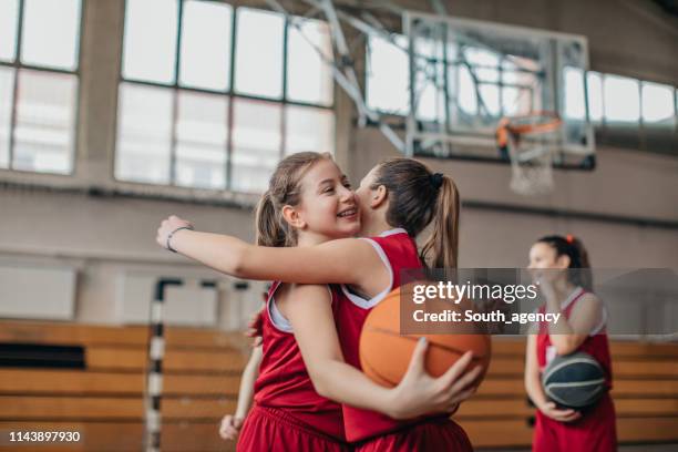 meisjes basketbal spelers knuffelen op de rechter na wedstrijd - basketball stockfoto's en -beelden