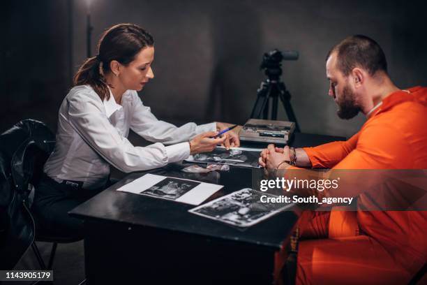woman detective and male prisoner in interrogation room - probation stock pictures, royalty-free photos & images