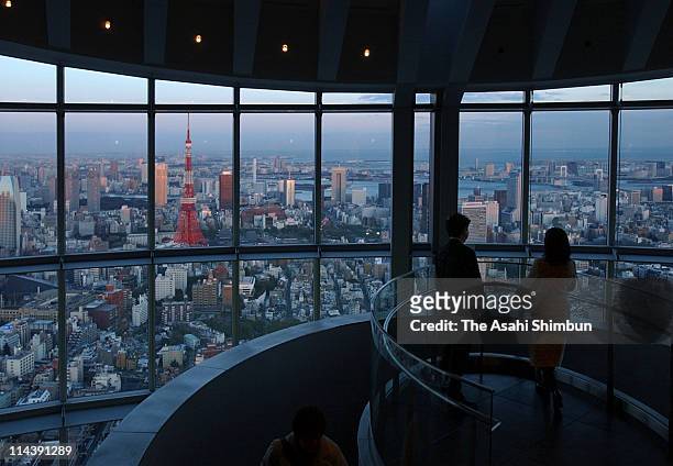 Visitors watch the cityscape of Tokyo during the press preview of Tokyo City View, sightseeing floor of Roppongi Hills on March 11, 2003 in Tokyo,...