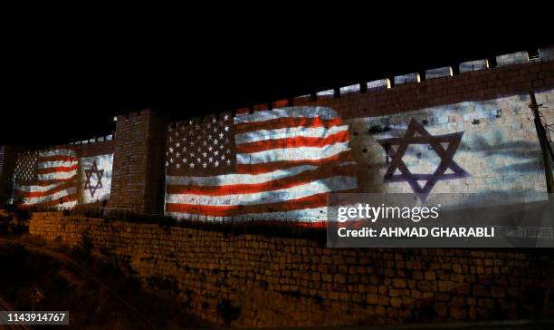 The Israeli and United States flags are projected on the walls of the ramparts of Jerusalem's Old City, to mark one year since the transfer of the US...