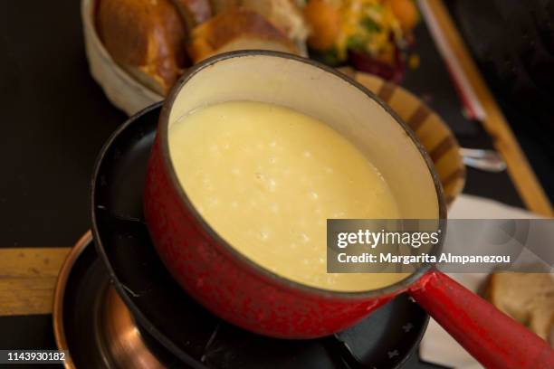 cheese fondue melting and bread - fondue stock-fotos und bilder