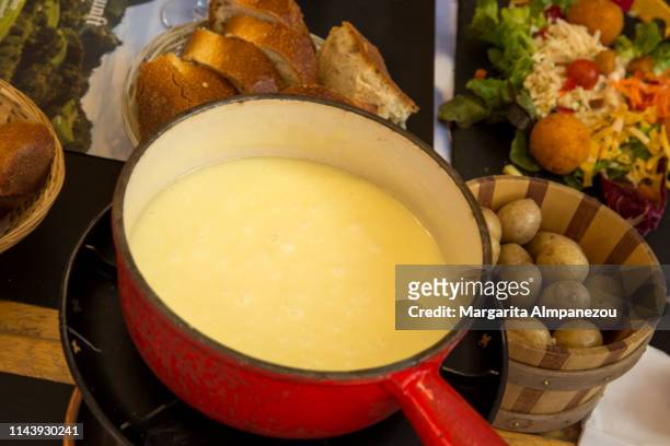 cheese fondue with potatoes and bread - fondue stock-fotos und bilder