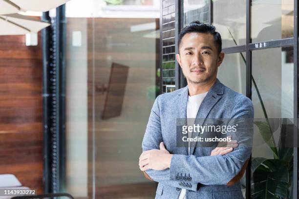 erfolgreicher asiatischer unternehmer in einem modernen coworking space - geschäftskleidung stock-fotos und bilder