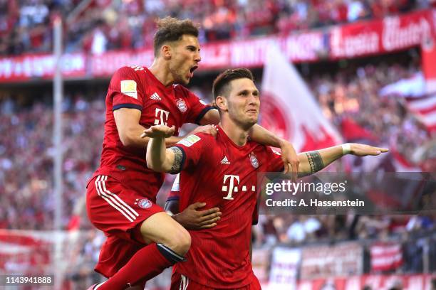 Niklas Suele of Bayern Muenchen celebrates scoring the opening goal with his team mate Leon Goretzka during the Bundesliga match between FC Bayern...