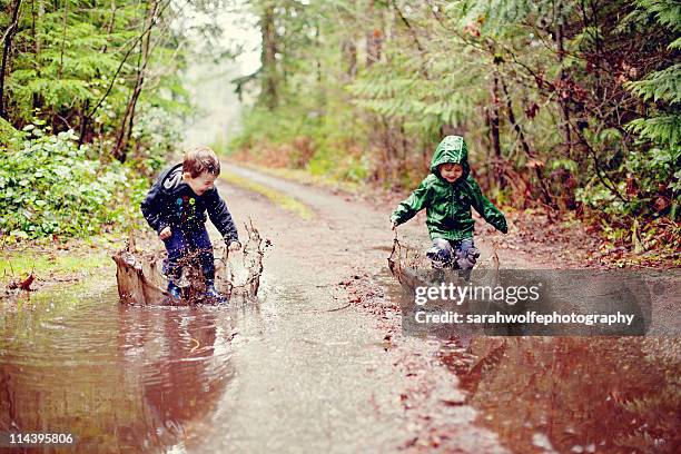 children in mud puddles - pfütze stock-fotos und bilder