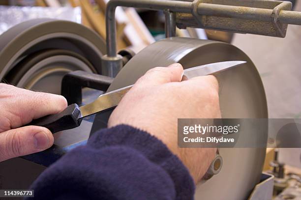 knife sharpening on wet grinder - scherp stockfoto's en -beelden
