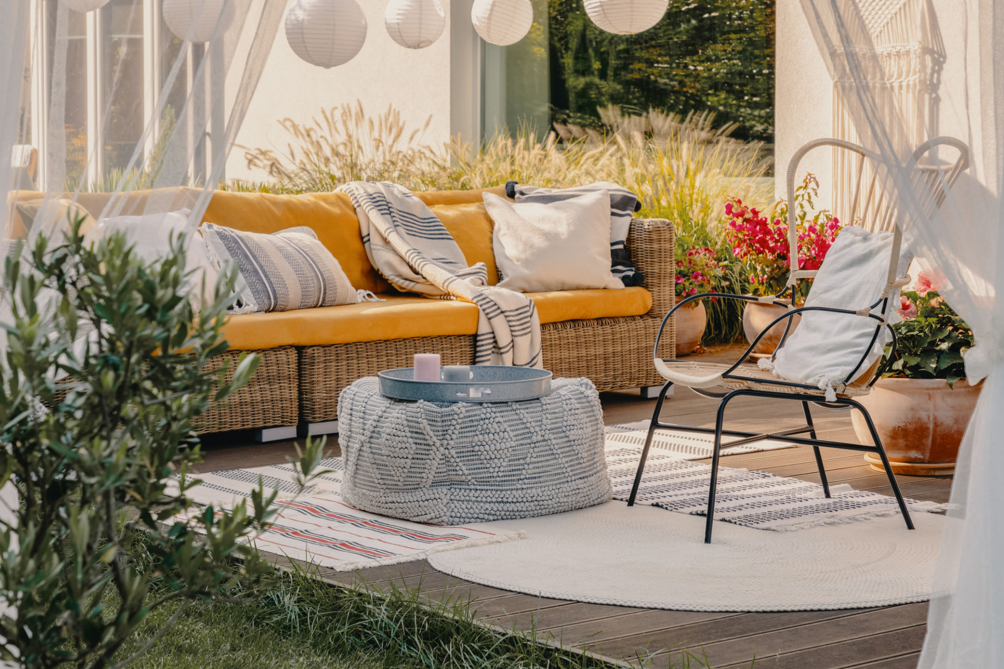 Real photo of an armchair, pouf as a table and wicker couch on a terrace Real photo of an armchair, pouf as a table and wicker couch on a terrace