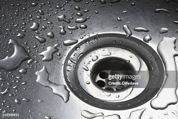 water drops around plughole in stainless steel sink - plug hole stock pictures, royalty-free photos & images