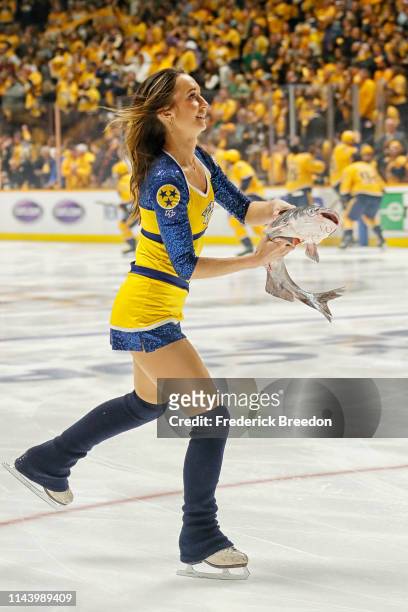 Member of the ice crew carries away a catfish that was thrown onto the ice prior to the first period of Game Five of the Western Conference First...