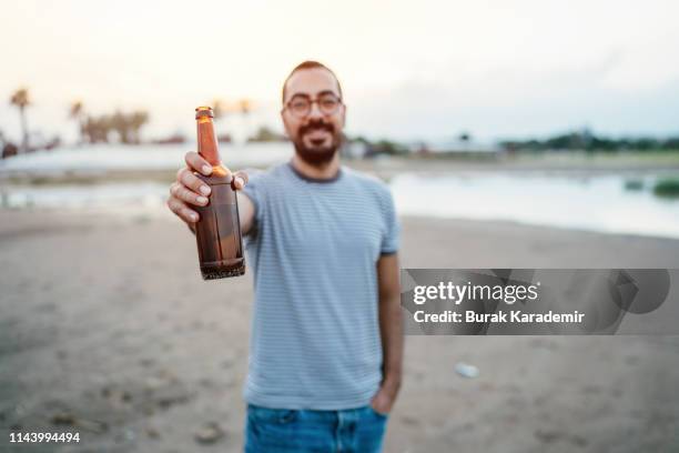 cheers (toast) - holding bottle stock pictures, royalty-free photos & images