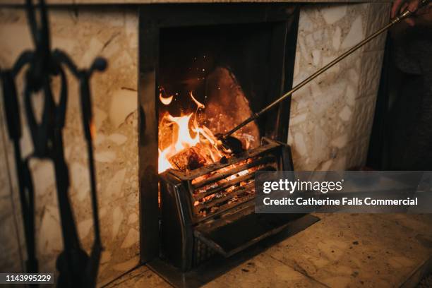 open log fire - stoking stock pictures, royalty-free photos & images