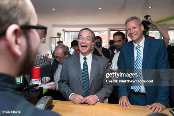 Leader of the Brexit Party Nigel Farage laughs while visting a vape shop on the High Street with Brexit Party candidate Nathan Gill on May 15, 2019...