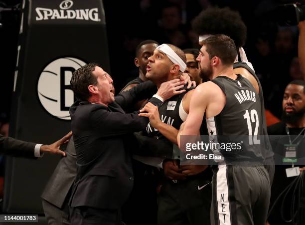 Head coach Kenny Atkinson and Joe Harris of the Brooklyn Nets hold back Jared Dudley at Barclays Center after a foul by Joel Embiid of the...