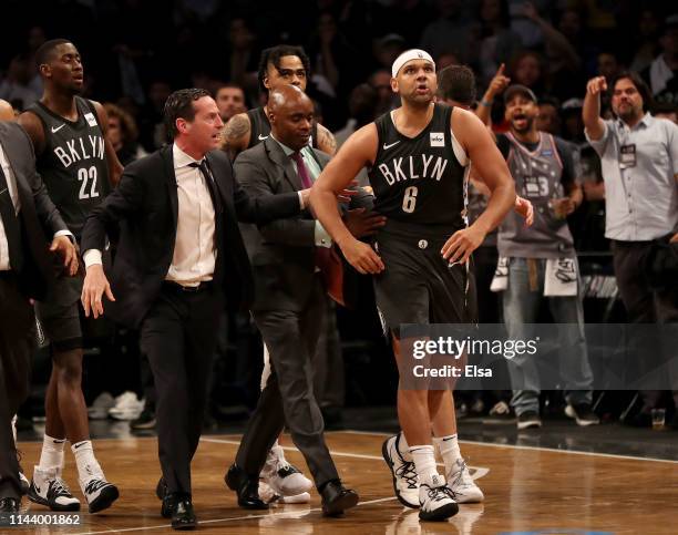 Head coach Kenny Atkinson of the Brooklyn Nets walks with Jared Dudley after a scuffle following a foul by Joel Embiid of the Philadelphia 76ers in...