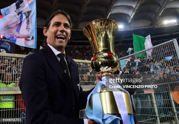 Lazio's Italian coach Simone Inzaghi celebrates as he holds the Tim Cup trophy during the trophy ceremony after winning the Coppa Italia final match...
