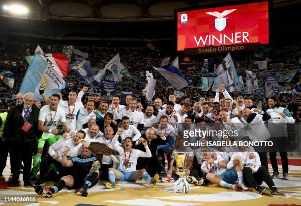 Lazio's team players and members of staff celebrate as they hold the Tim Cup trophy during the trophy ceremony after winning the Coppa Italia final...