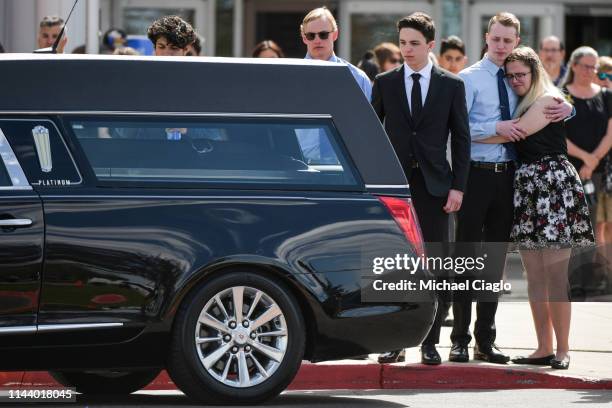 People embrace as Kendrick Castillo's casket is loaded into a hearse after a celebration of life ceremony at Cherry Hills Community Church on May 15,...