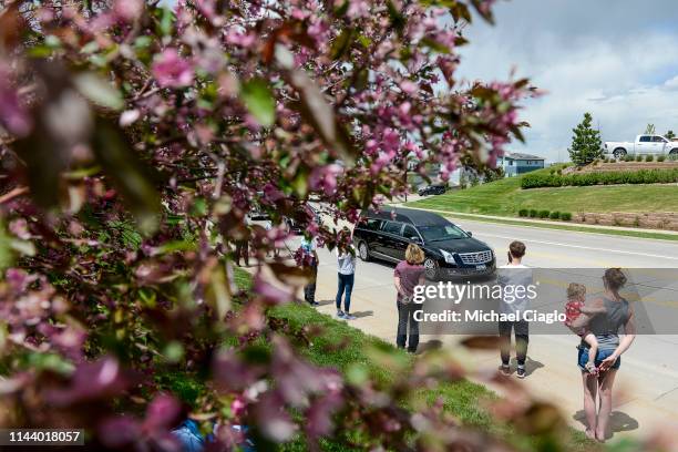 People line the street as a hearse carrying the body of Kendrick Castillo heads toward a celebration of life ceremony at the Cherry Hills Community...