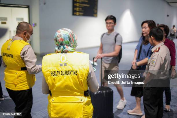 Health officer uses a thermal head to detect a monkeypox virus on arriving passengers at Soekarno-Hatta International Airport in Tangerang near...