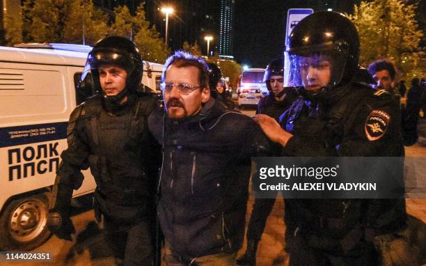 Police officers detain a activist protesting against a plan to build an Orthodox cathedral at a construction site in a park in the Russian Urals city...
