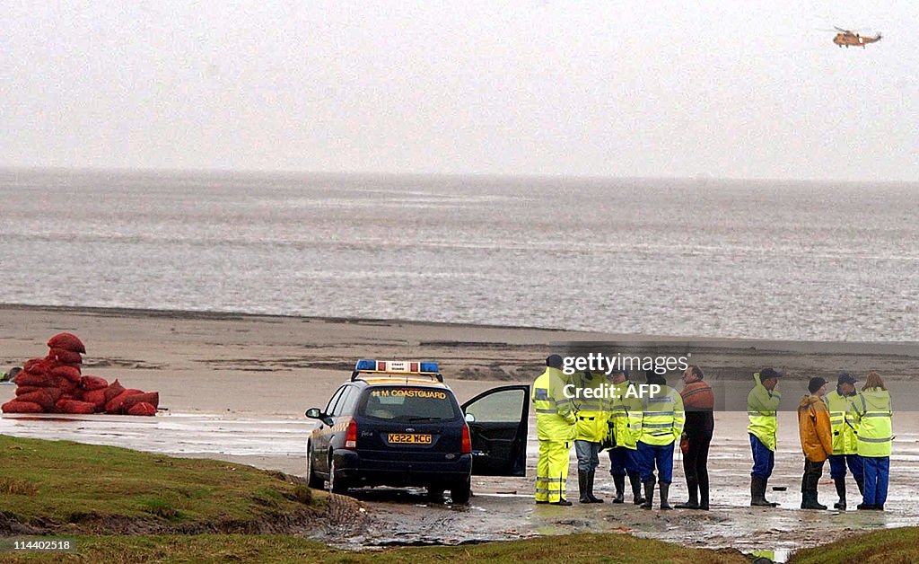 Rescue workers watch a helicopter search