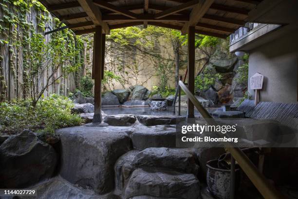 An outdoor hot springs bath is seen at the Shousenkaku Kagetsu inn in Yuzawa, Niigata Prefecture, Japan, on Tuesday, May 7, 2019. For Japans growing...