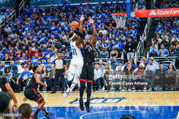 Terrence Ross of the Orlando Magic dunks the ball over Serge Ibaka of the Toronto Raptors during a game at Amway Center on April 19, 2019 in Orlando,...