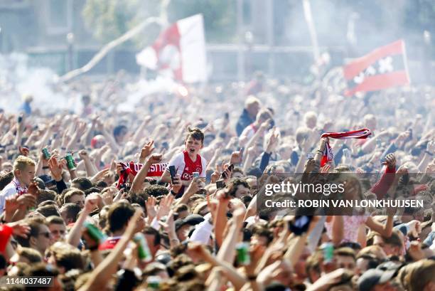 Ajax Amsterdam football supporters celebrate their club's 34th national champion title after winnning the 2019 Dutch Eredivisie championship outside...